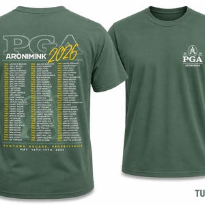 K&ouml;nnte beinhalten: T-Shirt in Rasengr&uuml;n mit der Aufschrift "PGA ARONIMINK 2026" und einer Namensliste auf der R&uuml;ckseite. Auf der Vorderseite des Shirts sind das PGA-Logo und "ARONIMINK" abgebildet. Es ist ein Rundhals-Modell.