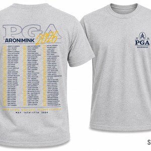 K&ouml;nnte beinhalten: Sportgraues T-Shirt mit dem PGA Aronimink 2026 Logo auf der Vorderseite und einer Namensliste auf der R&uuml;ckseite. Auf der R&uuml;ckseite des Shirts steht au&szlig;erdem der Text "MAY 14TH-17TH 2026".