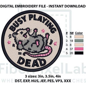 May include: A circular digital embroidery design featuring a gray and white opossum lying on its back with its tongue out. The text BUSY PLAYING DEAD is arched around the opossum in black. Small pink stars surround the opossum on a beige background.