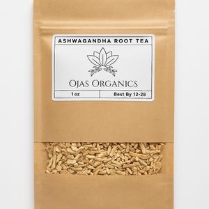 May include: A brown paper bag of Ashwagandha Root Tea from Ojas Organics. The bag has a clear window showing the tea inside. The label reads "Ashwagandha Root Tea" and "Ojas Organics". The bag contains 28 grams of tea.