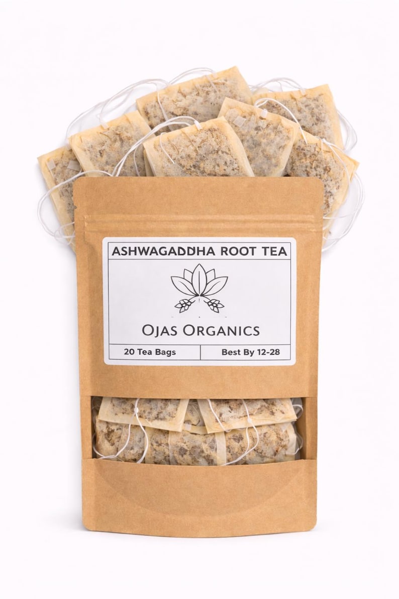 Puede incluir: Una bolsa de papel marr&oacute;n de t&eacute; de ra&iacute;z de Ashwagandha Ojas Organics con 20 bolsitas de t&eacute;. La bolsa tiene una etiqueta blanca con un gr&aacute;fico de flor de loto y el texto "Best By 12-28". Las bolsitas de t&eacute; son visibles encima y debajo de la bolsa.