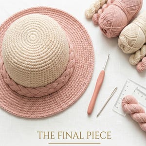 Puede incluir: Un sombrero de ganchillo bicolor con copa color crema y ala rosa empolvado con un detalle trenzado. Incluye ovillos de lana rosa y crema, un ganchillo rosa, una aguja de coser de metal y una regla transparente con marcas en centímetros.
