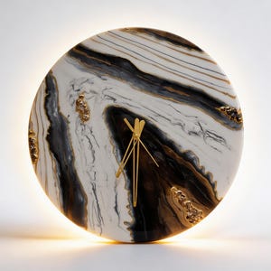Könnte beinhalten: Eine runde Wanduhr mit einem Marmormuster in Schwarz-, Weiß- und Goldtönen. Das Zifferblatt hat eine glänzende Oberfläche mit eingebetteten goldfarbenen Kristallakzenten und dünnen, goldfarbenen Metallzeigern. Ein warmes Licht leuchtet dahinter.