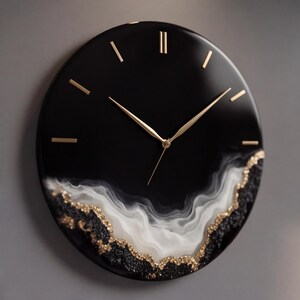Puede incluir: Un reloj de pared redondo con esfera negra brillante, manecillas doradas y marcadores de hora dorados. La parte inferior presenta un diseño de resina blanca con remolinos, acentuado con purpurina negra y dorada en el borde.