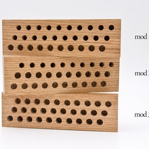 May include: Three wooden blocks with a grid of holes, labeled "mod 1", "mod 2", and "mod 3".
