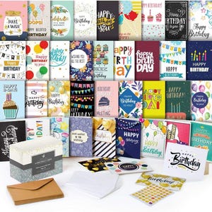Könnte beinhalten: Eine Sammlung von Geburtstagskarten mit verschiedenen Designs, darunter Ballons, Kuchen und feierliche Texte. Die Karten sind in verschiedenen Farben und Stilen gehalten, mit einer Kartenbox und Umschlägen im Vordergrund. Die Karten sind für Geburtstagsfeiern.