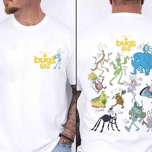 May include: White t-shirt with the Disney Pixar film title "A Bug's Life." The front has the title and an ant cartoon. The back features illustrations of characters from the film, such as Flik, Dot, and Heimlich.