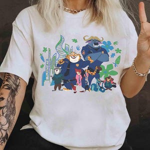 May include: White t-shirt with a vibrant graphic of Zootopia characters. The design showcases animal characters in police uniforms against a cityscape. The tee has short sleeves and is made of a soft material.