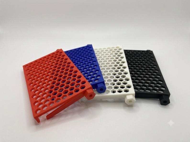 May include: A set of four rectangular panels featuring a repeating hexagonal grid pattern. Each panel is a different solid color: red, blue, white, and black. Each piece includes a small hexagonal protrusion on one side and a support leg.