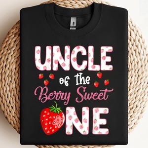 May include: Black sweatshirt with the text "UNCLE of the Berry Sweet ONE" in white and pink lettering. The word "UNCLE" is decorated with strawberry graphics. A large strawberry graphic is on the bottom left.