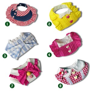 May include: A collection of eight pet bandanas in various styles. The bandanas feature a range of colors, including red, blue, yellow, and pink. Some bandanas have bows, lace, and heart-shaped accents. The bandanas are designed with different patterns, such as gingham and solid colors.