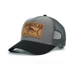 May include: Gray and black trucker hat with a curved brim. The hat features a leather patch with the text "RANGLELAB" and a marlin fish illustration. The back of the hat is mesh.