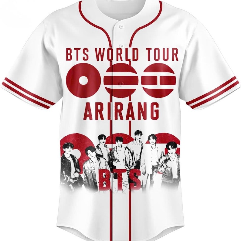 May include: White baseball jersey with red accents and the text "BTS WORLD TOUR ARIRANG". The jersey features a red design with the band's name and a photo of the band members. The sleeves have red stripes.