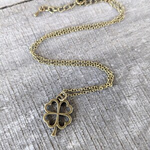 May include: A gold chain necklace with a four-leaf clover pendant.