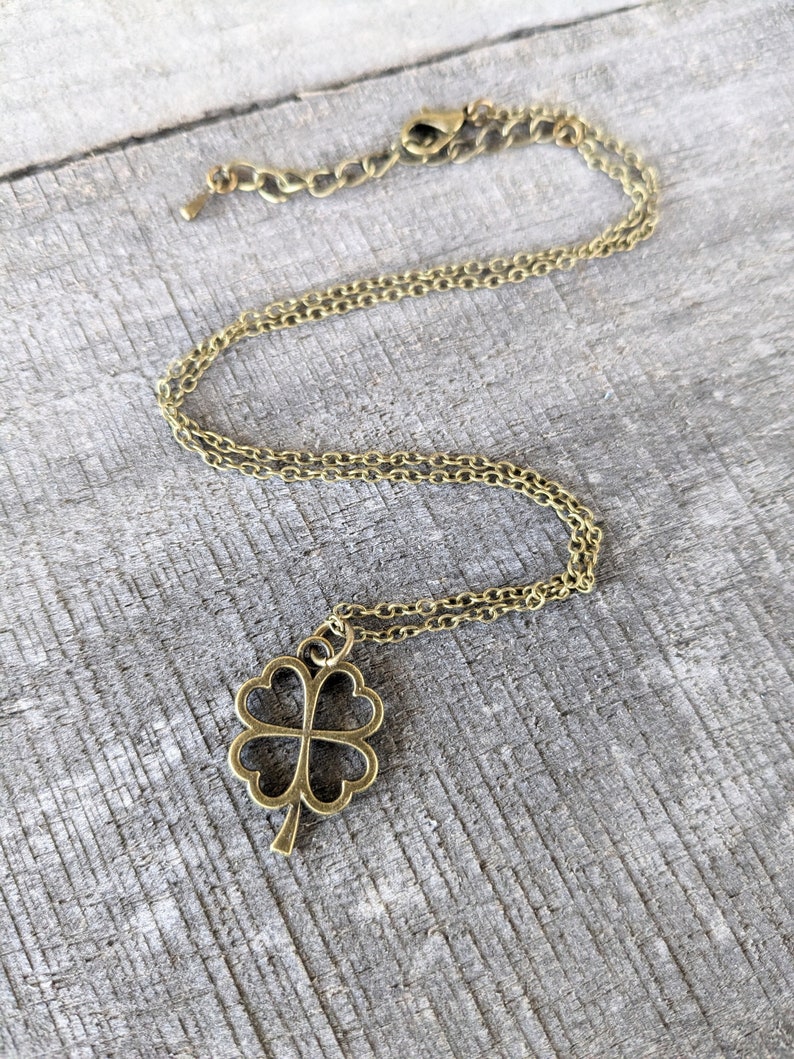 May include: A gold chain necklace with a four-leaf clover pendant.