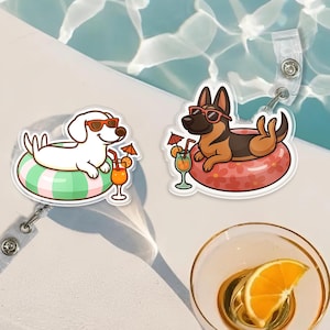 Puede incluir: Dos portatarjetas con perros de dibujos animados con gafas de sol relajándose en flotadores inflables con cócteles. Un perro es blanco, el otro es un pastor alemán. El fondo incluye una piscina y un vaso con una rodaja de naranja.
