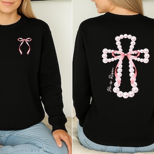 May include: A white ceramic mug with a black handle and the text "But First, Coffee" in a bold, black font. The mug is set against a blurred background, suggesting a cozy setting.