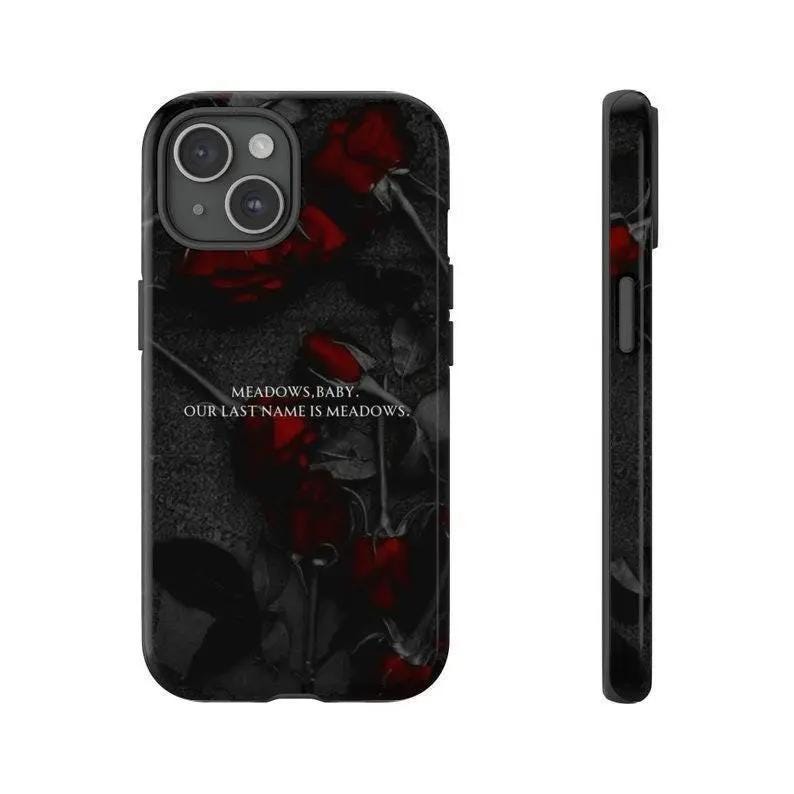 K&ouml;nnte beinhalten: Eine schwarze Smartphone-H&uuml;lle mit einem dunklen, stimmungsvollen Blumenmuster aus tiefroten Rosen auf anthrazitfarbenem Hintergrund. Der Text MEADOWS, BABY. OUR LAST NAME IS MEADOWS. ist mittig in Wei&szlig; aufgedruckt. Die H&uuml;lle hat eine Doppelkamera-Aussparung.