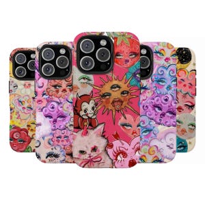 May include: A collection of phone cases with colorful, whimsical designs. The cases feature illustrations of faces, eyes, clouds, strawberries, and a devil character. The color palette includes pink, yellow, and purple hues.