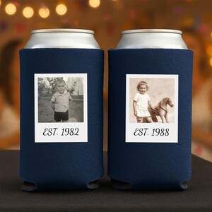 May include: Two navy blue foam can coolers featuring white square frames with black and white photographs of children. The left cooler displays a child and the text EST. 1982, while the right cooler shows a child with a toy horse and EST. 1988.