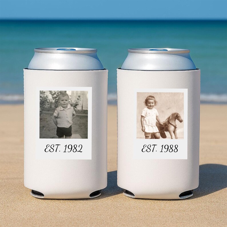 May include: Two white foam can coolers featuring personalized black and white photographs. The left cooler displays a child with the text EST. 1982. The right cooler shows a child with a toy horse and the text EST. 1988. Both are cylindrical.