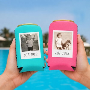 May include: Two foam can coolers, one turquoise and one pink, each featuring a white square frame containing a black and white photograph. The turquoise cooler displays a child and the text EST. 1982, while the pink cooler shows a child with a toy horse and the text EST. 1988.
