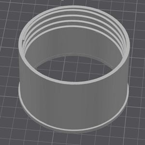 May include: A cylindrical, gray 3D-printed object with a series of concentric rings at the top. The object has a wide base and a smooth, untextured surface. The object is likely a component or part of a larger assembly.
