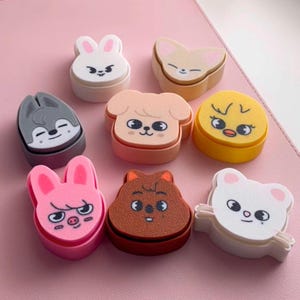 May include: A selection of nine colourful, animal-shaped erasers. The erasers feature designs of a bunny, fox, wolf, dog, chick, pig, bear, and a brown animal. Each eraser is approximately 4 cm in height and width.