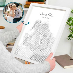 K&ouml;nnte beinhalten: Ein wei&szlig; gerahmter Druck mit einer Silhouette eines Paares, die aus Text besteht. Der Druck enth&auml;lt die Namen "Lisa & Pete" und das Datum "APRIL 04, 2025". Ein eingesetztes Foto zeigt das Paar. Die Person h&auml;lt den Druck.