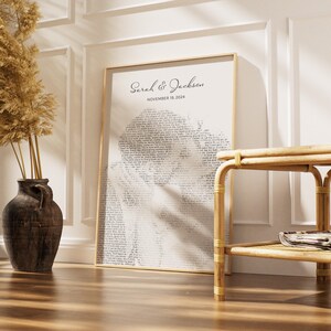 K&ouml;nnte beinhalten: Ein gerahmter Druck mit den Namen "Sarah & Jackson" und dem Datum "November 19, 2024" oben. Der Druck zeigt eine Silhouette, die mit Text gef&uuml;llt ist. Links befindet sich eine dunkelbraune Vase mit getrockneten Pflanzen.