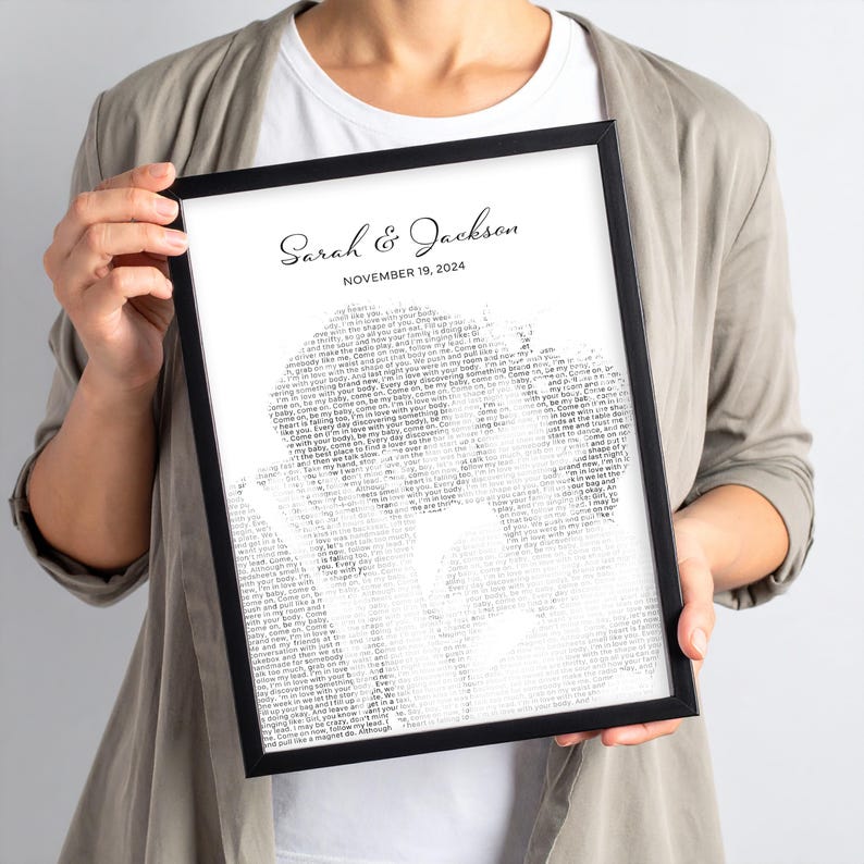 K&ouml;nnte beinhalten: Ein schwarz gerahmter Druck mit den Namen "Sarah & Jackson" und dem Datum "NOVEMBER 19, 2024" oben. Das Bild ist eine Silhouette von zwei Personen, die aus Text bestehen. Der Druck wird von einer Person gehalten.