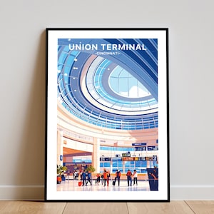 May include: Framed art print of Union Terminal, Cincinnati. The illustration highlights the building's interior, focusing on its architectural features, including a large, circular glass ceiling. People are shown in the terminal, with luggage. The print is in a black frame.