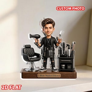 May include: A 2D flat acrylic figure of a hair stylist holding a hairdryer and scissors. The figure stands in front of a black salon chair and a small rolling cart with hair care products. The base is engraved with "Hair Stylist Ethan".