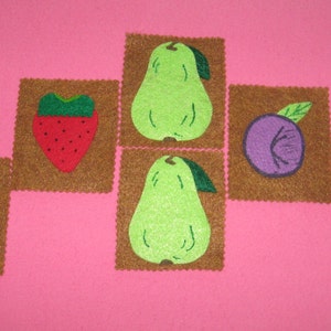 May include: A set of felt fruit patches, including strawberries, pears, and plums. The patches are brown with green and red accents.