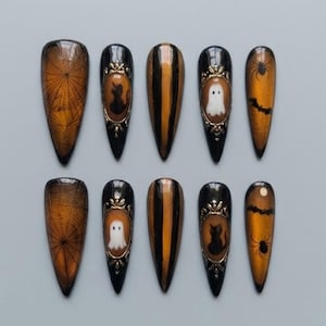 May include: A set of ten almond-shaped press-on nails featuring a Halloween theme. The designs include black and orange spiderwebs, gold-framed silhouettes of black cats and white ghosts, vertical black and orange stripes, and bats with spiders.