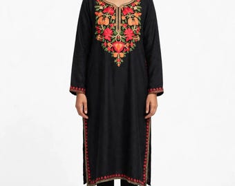 May include: A black long-sleeved tunic featuring a vibrant floral embroidery pattern in shades of red, orange, and green around the neckline, cuffs, and side slits, paired with black leggings and black open-toe sandals.