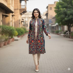 Può includere: Un cappotto blu navy ricamato con un motivo floreale rosso, arancione e verde. Il cappotto è indossato sopra un top color crema e pantaloni beige. L'outfit è completato da tacchi color crema.