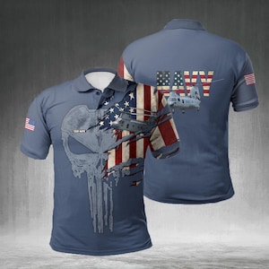 May include: A blue polo shirt featuring a distressed American flag design with a helicopter and a skull graphic. The shirt has the word "NAVY" on the back and a small American flag on the sleeve. The text "YOUR NAME" is also visible.