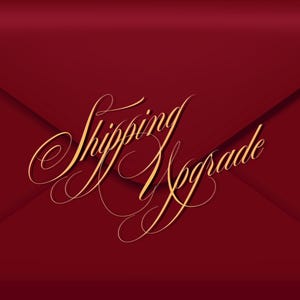 Puede incluir: Un sobre burdeos con las palabras "Shipping Upgrade" en elegante escritura dorada. El sobre tiene una textura sutil y un diseño clásico, perfecto para anuncios u ofertas especiales.