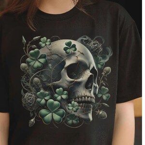 May include: Black t-shirt featuring a detailed illustration of a skull adorned with green shamrocks and intricate vines. The design has a gothic aesthetic, with a touch of St. Patrick's Day symbolism. The skull is rendered in shades of gray and white.
