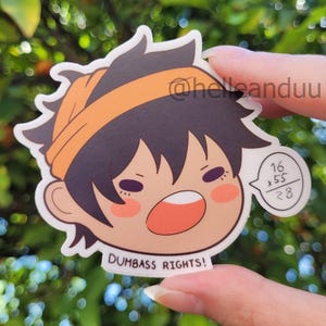 May include: A die-cut sticker featuring a cartoon character with black hair and an orange headband. The character has a surprised expression with an open mouth. Text on the sticker reads "DUMBASS RIGHTS!" and a math problem is in a speech bubble.
