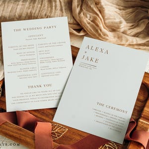 May include: Two light blue wedding programs with brown text. One program lists the wedding party, including the officiant, parents, and bridal party. The other program says "Alexa + Jake" with the date and location, and the ceremony details.