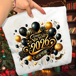 May include: White pillow with a festive design featuring black and gold balloons, the text "Happy New Year 2026", and a banner that reads "New Year". The design includes stars and decorative swirls, perfect for holiday decor.