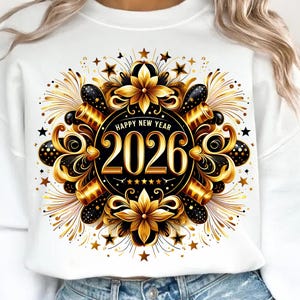May include: White sweatshirt with a festive New Year's design. The graphic features a black and gold circular emblem with the year 2026, surrounded by stars, fireworks, and floral elements. The words "Happy New Year" are above the year.