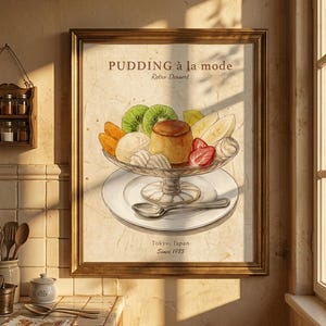 May include: A framed print of a retro dessert, "Pudding à la mode," featuring a glass dish filled with a custard dessert, kiwi, strawberries, and other fruits. The print includes the text "Tokyo, Japan Since 1985."