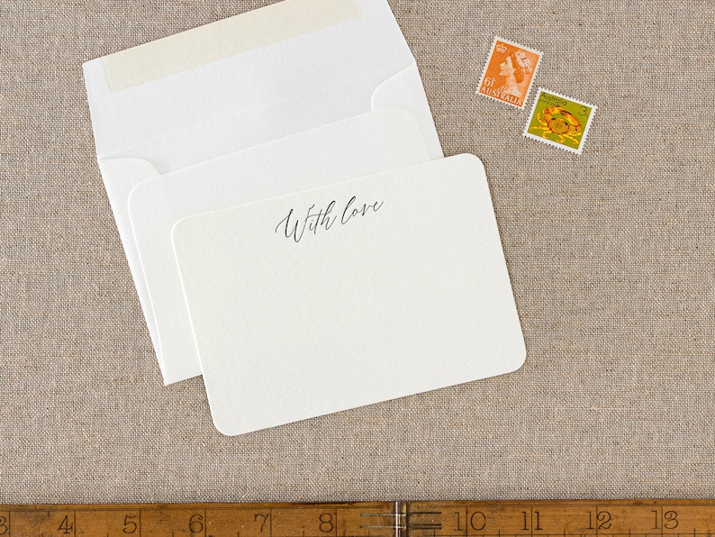 Small flat letterpress cards, printed with the text 'With love' at the top in a dark grey ink. Paired with matching ivory square flap envelopes.