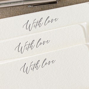 Small flat letterpress cards, printed with the text 'With love' at the top in a dark grey ink. Paired with matching ivory square flap envelopes.