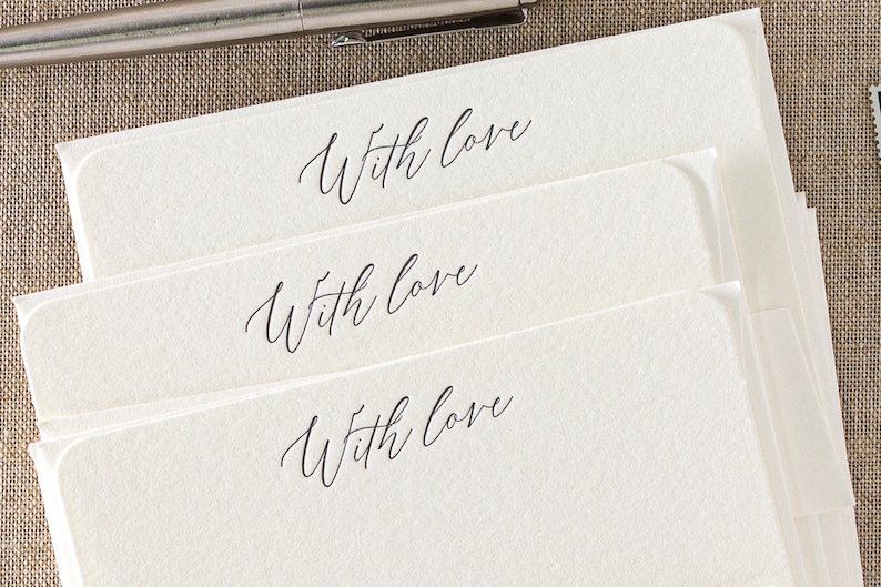 Small flat letterpress cards, printed with the text 'With love' at the top in a dark grey ink. Paired with matching ivory square flap envelopes.