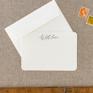 Small flat letterpress cards, printed with the text 'With love' at the top in a dark grey ink. Paired with matching ivory square flap envelopes.