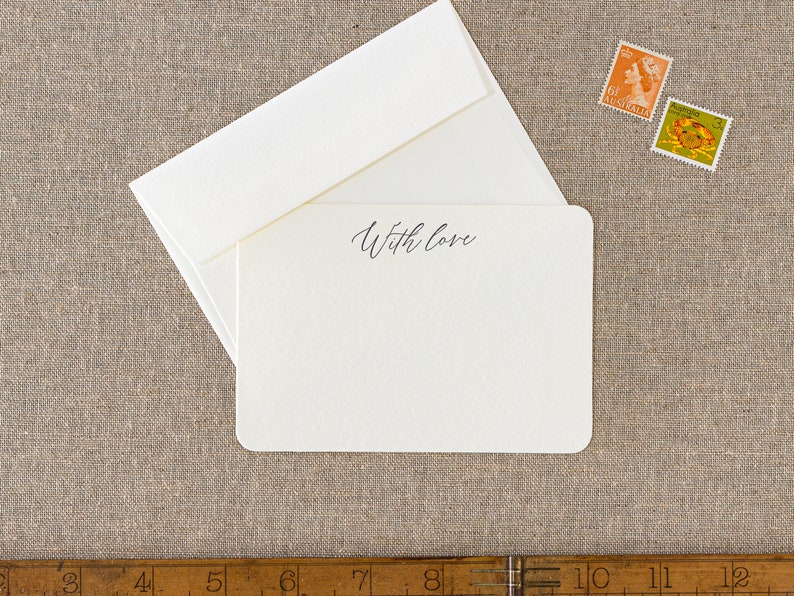 Small flat letterpress cards, printed with the text 'With love' at the top in a dark grey ink. Paired with matching ivory square flap envelopes.